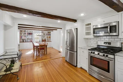 a kitchen with stainless steel appliances a stove a refrigerator and a dining table