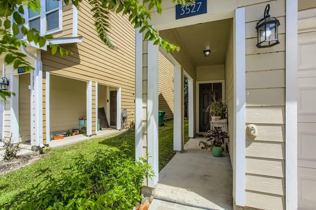 a view of a house with potted plants in front of door