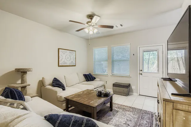 a living room with furniture a ceiling fan and a rug