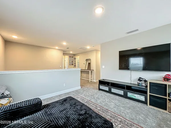 a view of a hallway with a livingroom and entryway