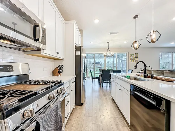 a open kitchen with stainless steel appliances granite countertop a stove and a wooden floors