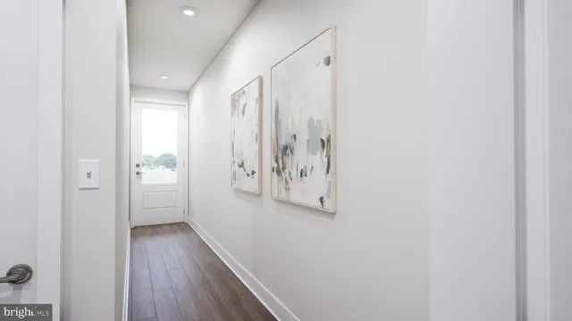 a view of a hallway with wooden floor and closet