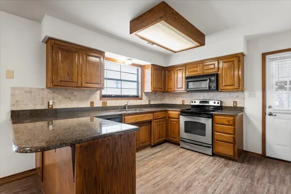 a kitchen with stainless steel appliances granite countertop a sink stove and microwave
