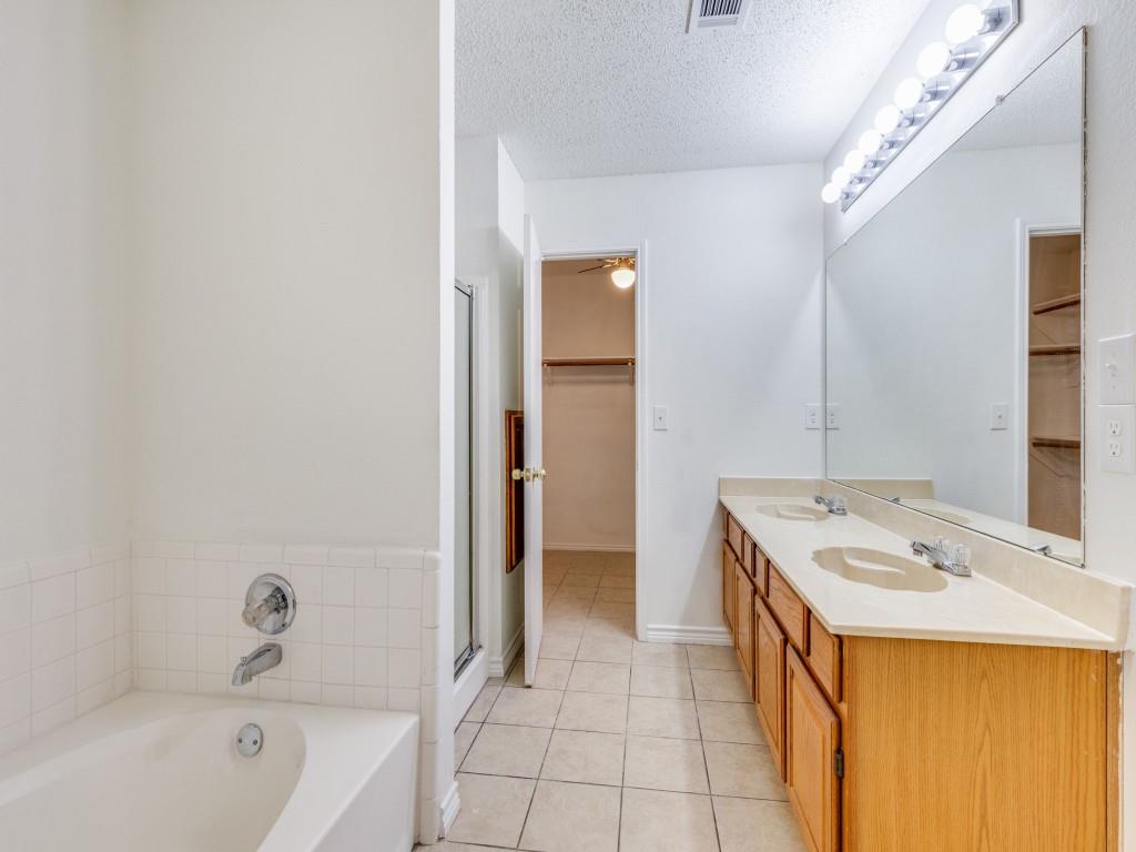4657 Misty Ridge Drive Fort Worth, TX 76137 - Photo 15 of 25 The primary bath is ensuite with ceramic tile, separate sjower and a garden tub !