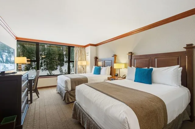 a bedroom with double bed and large windows