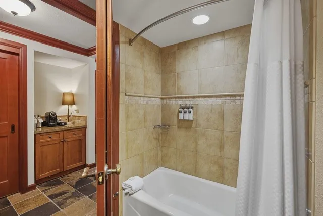 a bathroom with a granite countertop sink mirror bathtub and shower