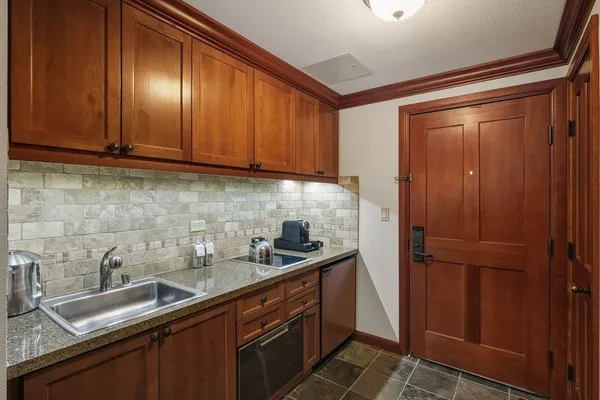 a kitchen with stainless steel appliances granite countertop wood cabinets and a sink