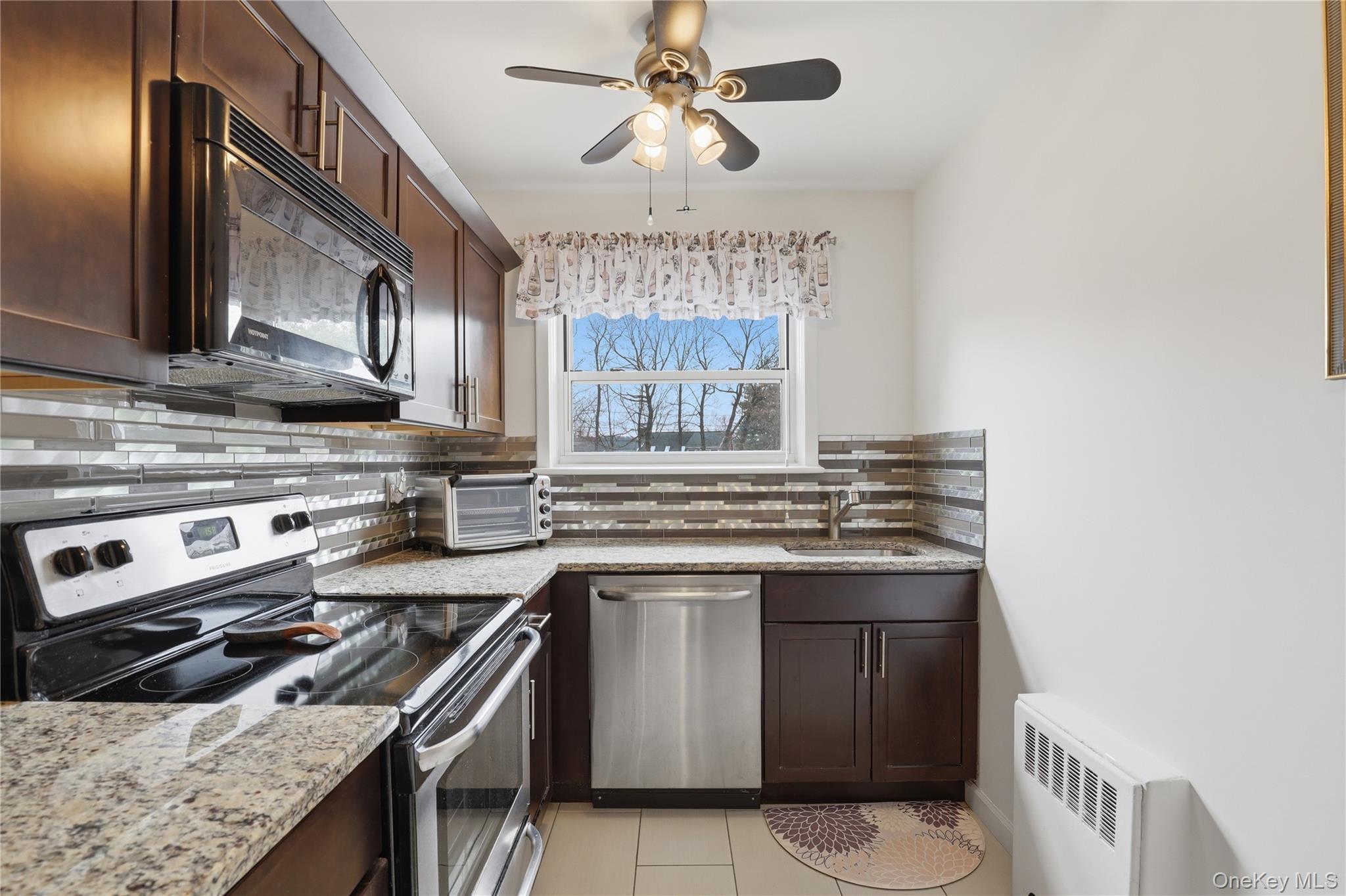 352 North State Road, Unit 1H Briarcliff Manor, NY 10510 - Photo 10 of 20 a kitchen with stainless steel appliances granite countertop a stove a sink and a refrigerator