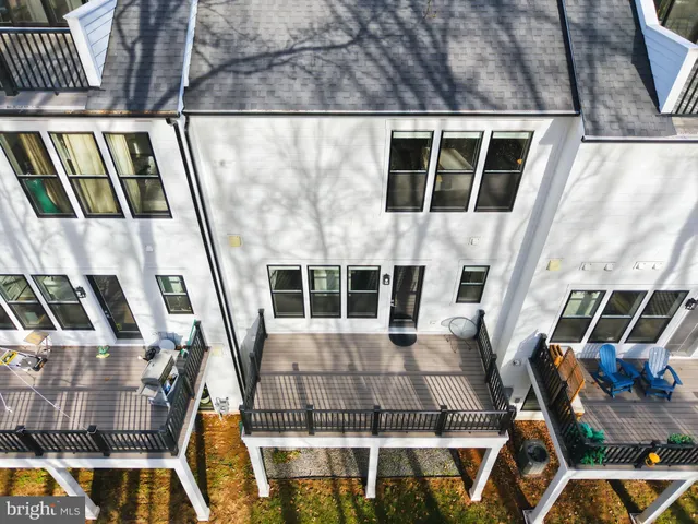 a kitchen with stainless steel appliances kitchen island granite countertop a dining table chairs and a refrigerator