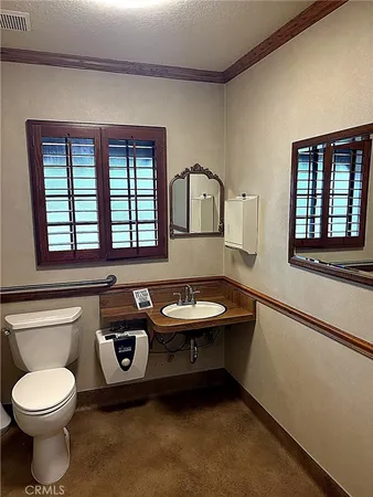 a bathroom with a sink a toilet and a window