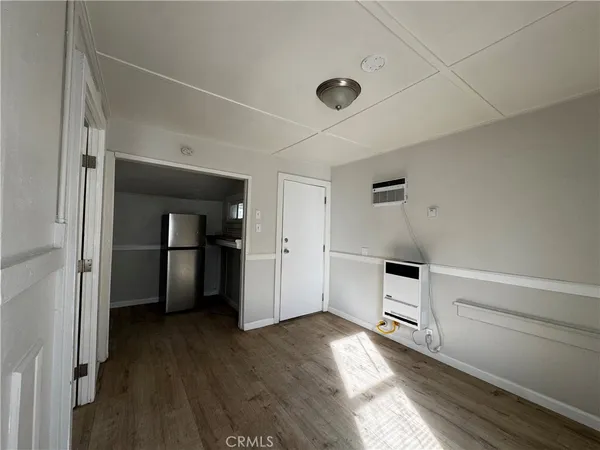 a view of a kitchen with a refrigerator a stove top oven and cabinets