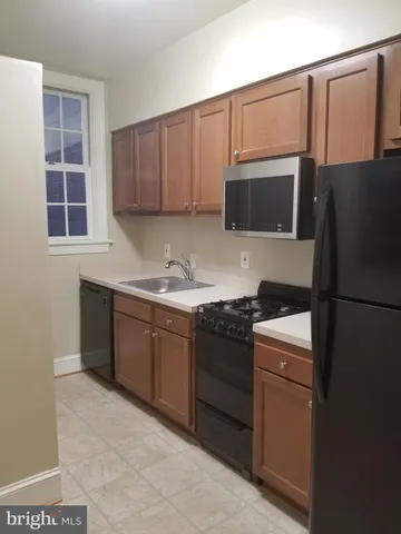 a kitchen with stainless steel appliances granite countertop a refrigerator stove a sink dishwasher and microwave