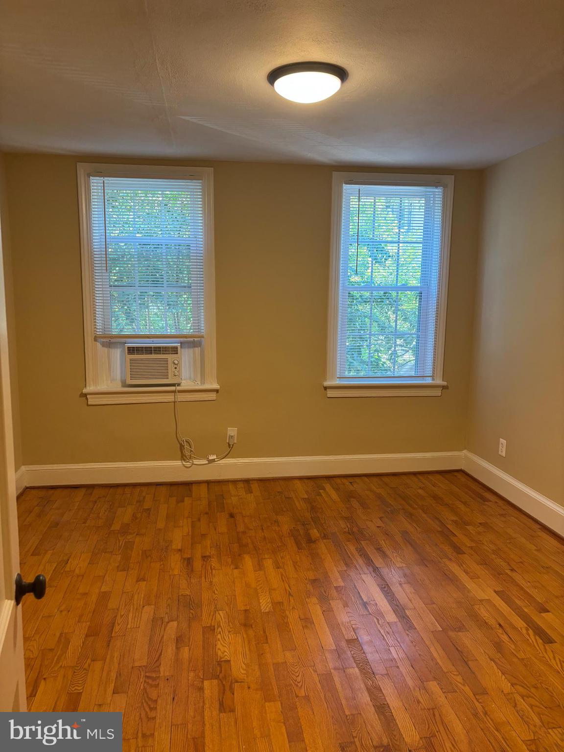 940 24th Street Northwest Washington, DC 20037 - Photo 6 of 12 a view of an empty room with a window and wooden floor