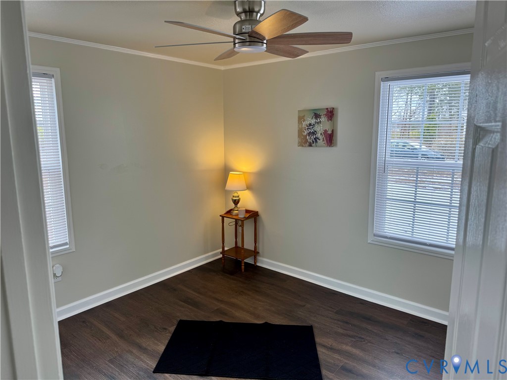 7279 Howerton Road Dunnsville, VA 22454 - Photo 12 of 17 an empty room with wooden floor a ceiling fan and windows