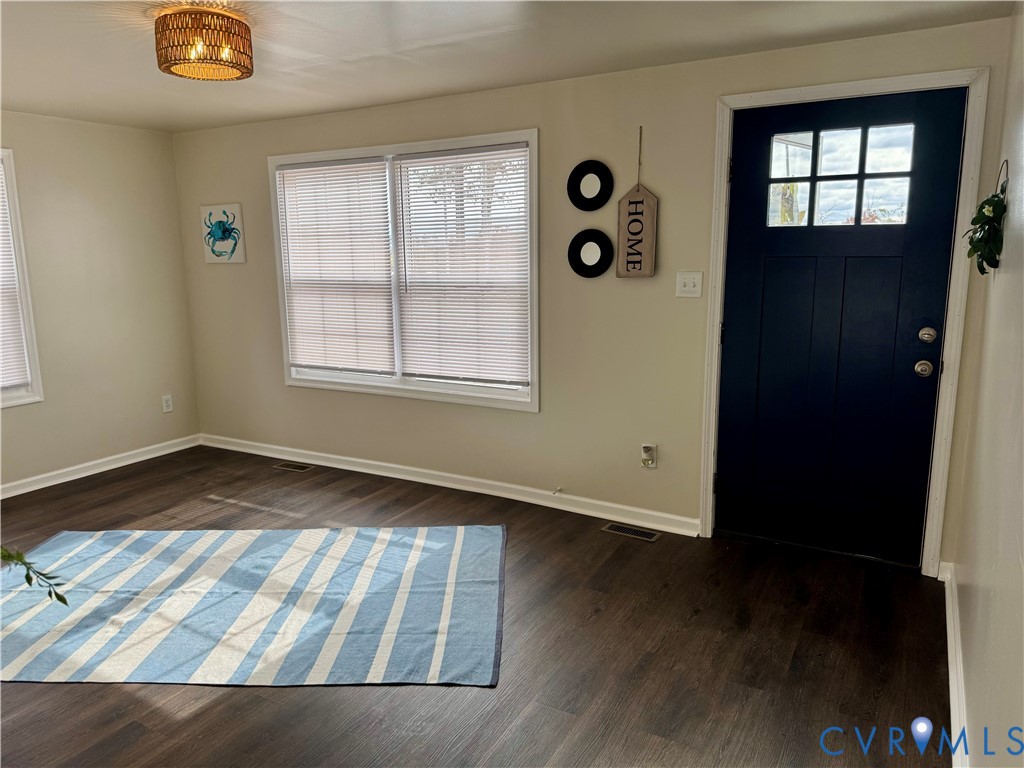 7279 Howerton Road Dunnsville, VA 22454 - Photo 2 of 17 an empty room with wooden floor and windows