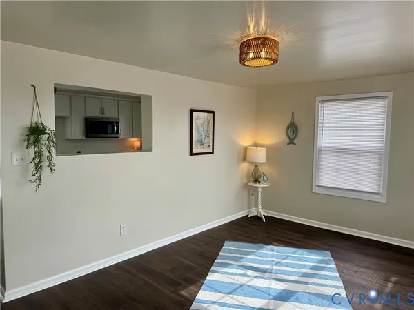 a front view of a house with wooden floor a potted plant and a chandelier