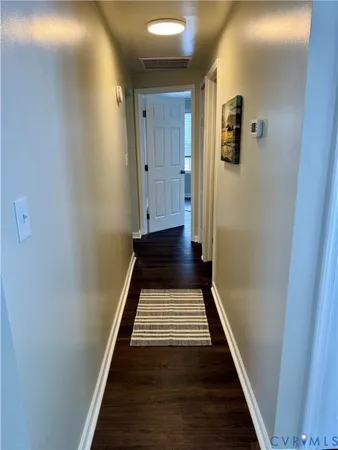 a view of a hallway with wooden floor and staircase
