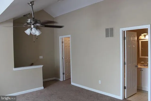 a view of a hallway with a chandelier fan