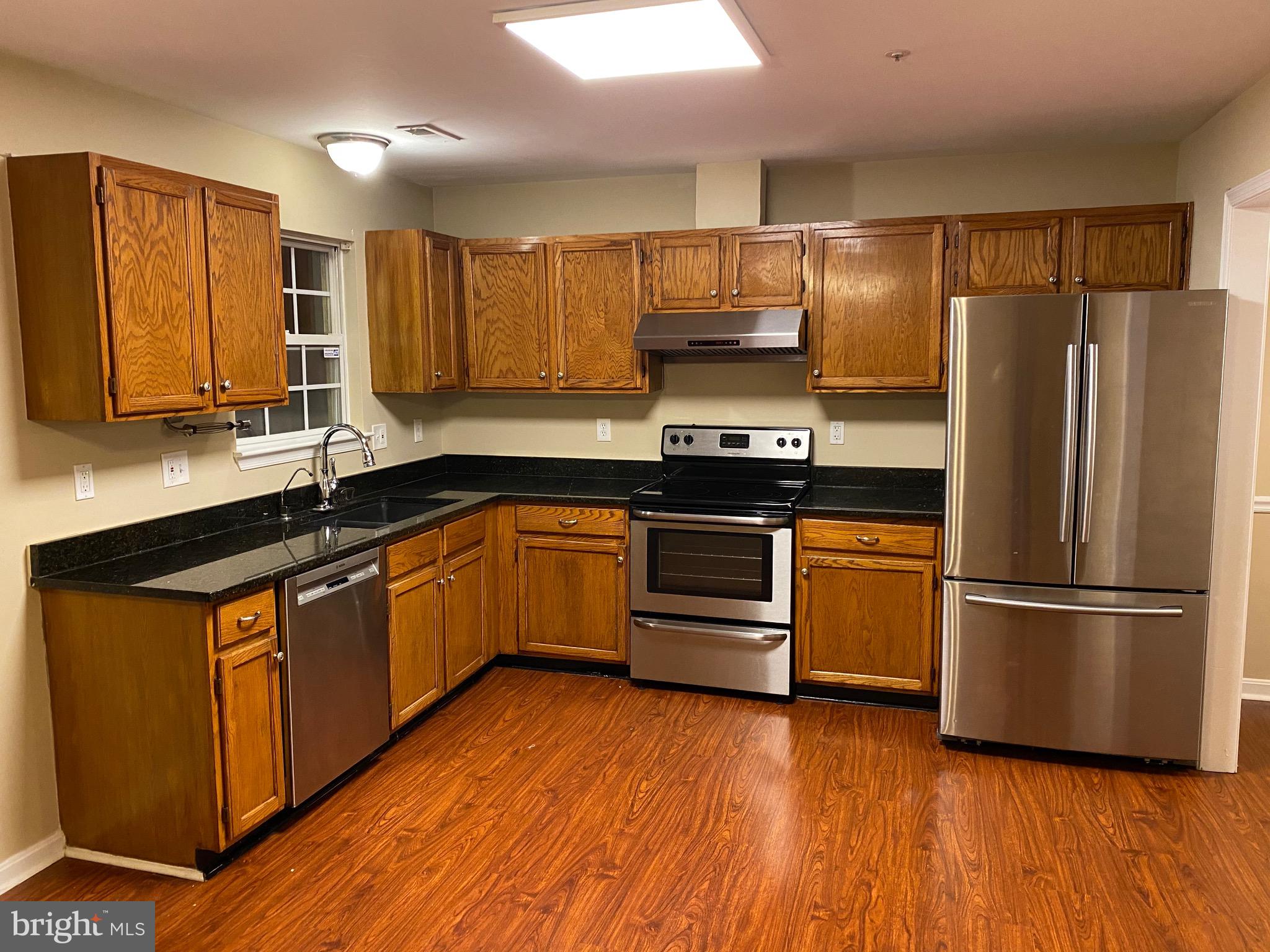 120 Langdon Farm Circle Odenton, MD 21113 - Photo 5 of 37 a kitchen with stainless steel appliances a refrigerator a sink and wooden floors