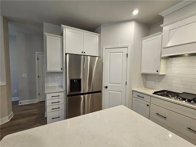 a kitchen with refrigerator a stove and cabinets