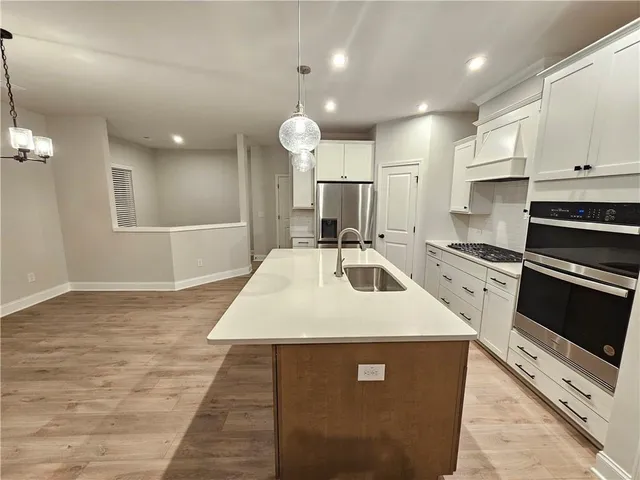 a kitchen with kitchen island a sink stainless steel appliances and cabinets