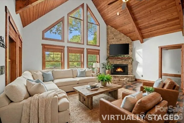 a living room with furniture a fireplace and a large window
