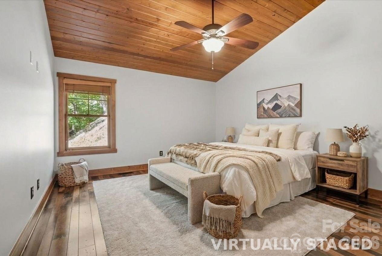 13 Miners Trace Road Burnsville, NC 28714 - Photo 18 of 34 a spacious bedroom with a bed and a chandelier