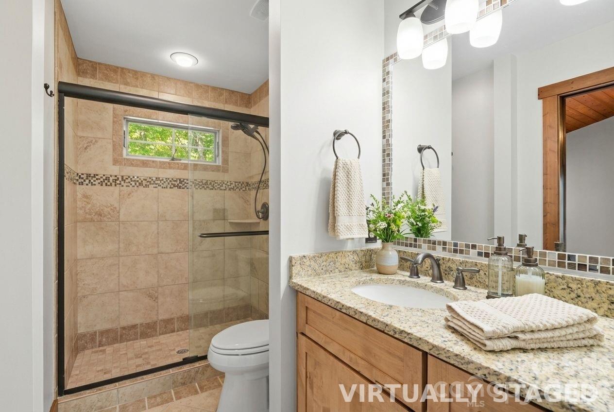 13 Miners Trace Road Burnsville, NC 28714 - Photo 24 of 34 a bathroom with a granite countertop sink a toilet a mirror and shower