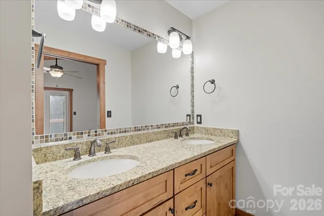 a bathroom with a granite countertop double vanity and a mirror