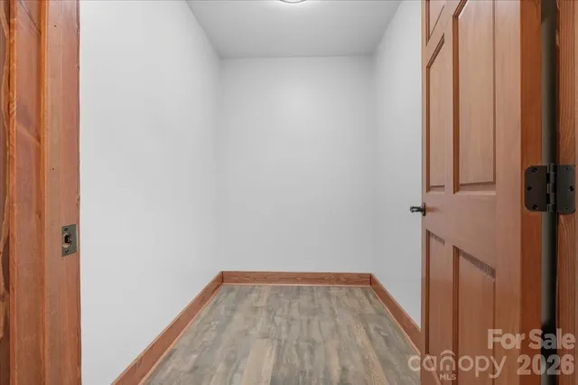 a view of a room with wooden floor and a window