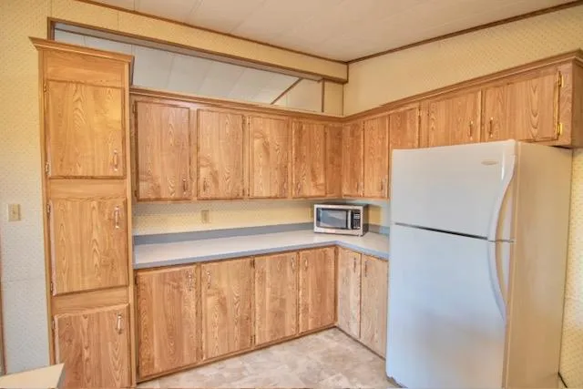 a kitchen with a refrigerator a sink and cabinets