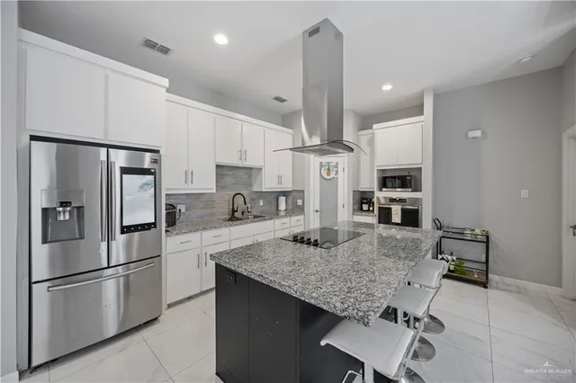 a kitchen with stainless steel appliances granite countertop a refrigerator a stove microwave and sink