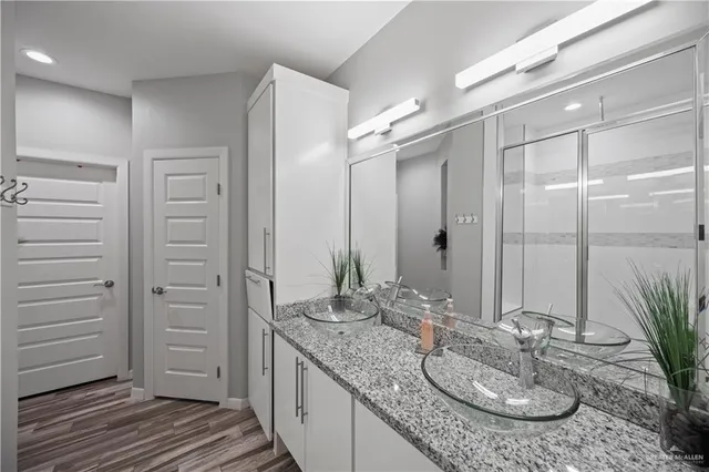 a bathroom with a granite countertop sink and a mirror
