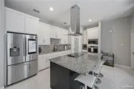 a kitchen with refrigerator and chairs