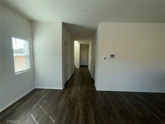 a view of a hallway with wooden floor and closet