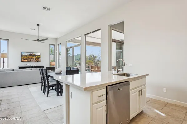 a dining hall with stainless steel appliances kitchen island a table and chairs in it