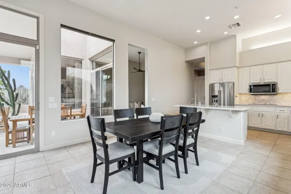 a dining area with stainless steel appliances kitchen island granite countertop a sink and cabinets
