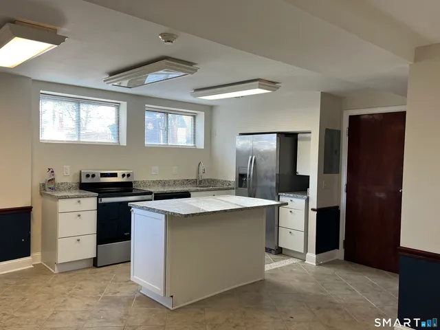 a kitchen with stainless steel appliances granite countertop a stove a refrigerator and a sink