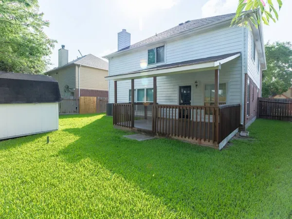 a view of a house with a yard and deck