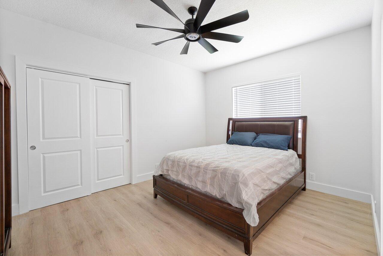8369 Southeast Island Way Jupiter, FL 33458 - Photo 19 of 41 a bedroom with a bed and a ceiling fan