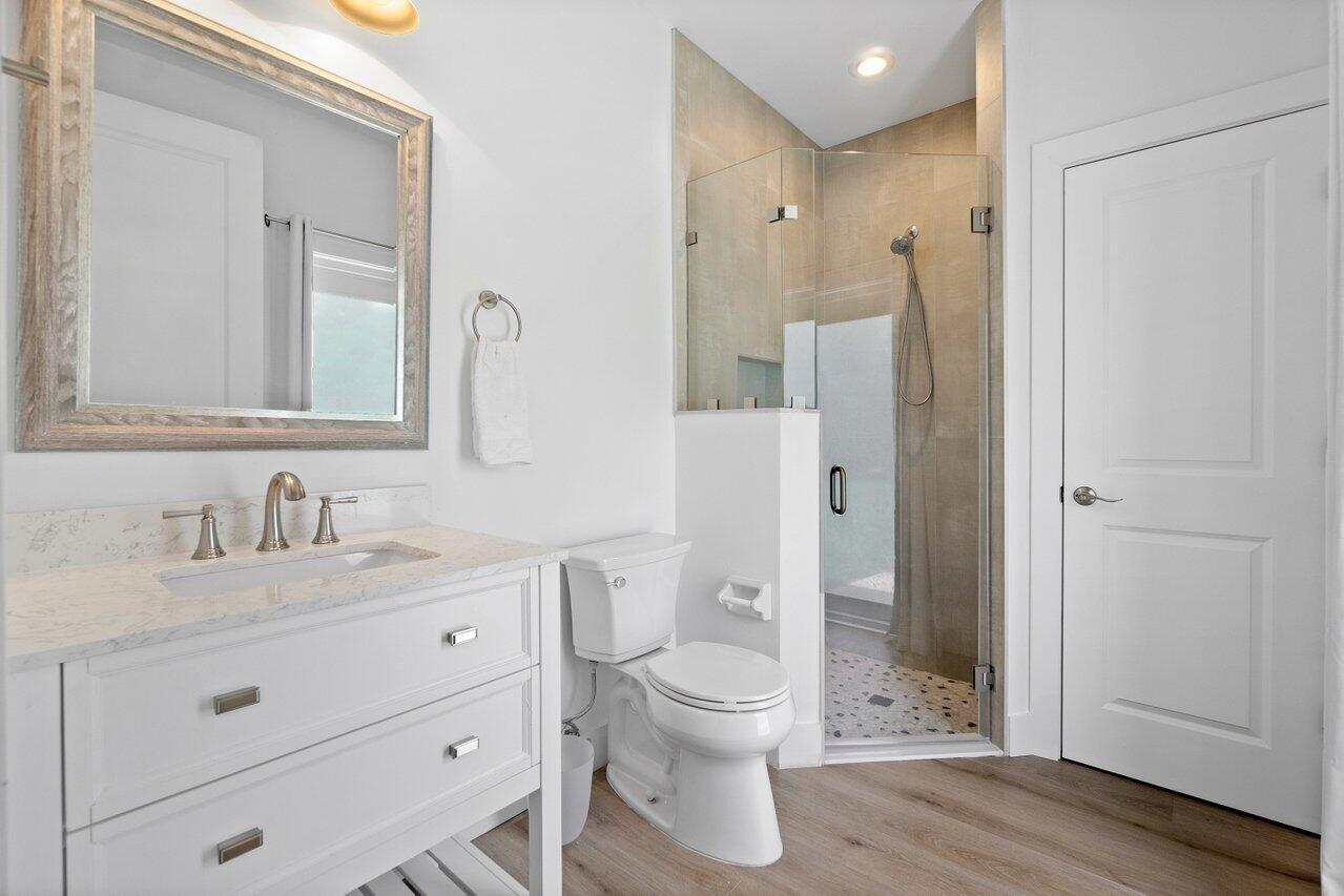 8369 Southeast Island Way Jupiter, FL 33458 - Photo 23 of 41 a bathroom with a toilet a sink and glass door