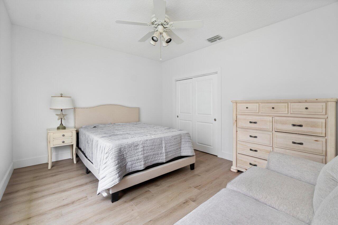 8369 Southeast Island Way Jupiter, FL 33458 - Photo 24 of 41 a bedroom with a bed and a chandelier