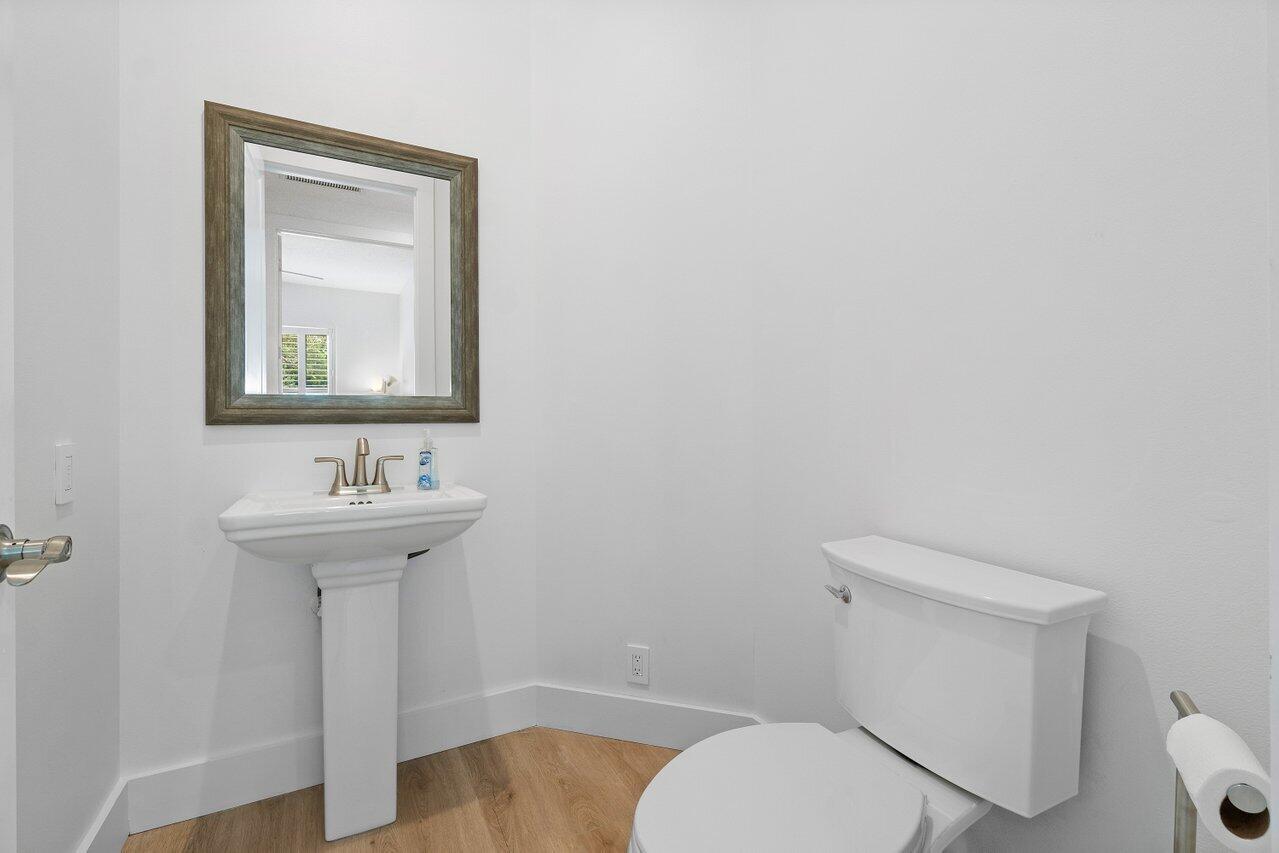 8369 Southeast Island Way Jupiter, FL 33458 - Photo 26 of 41 a bathroom with a toilet a sink and mirror