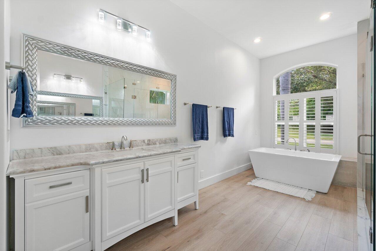 8369 Southeast Island Way Jupiter, FL 33458 - Photo 34 of 41 a spacious bathroom with a granite countertop sink mirror and bathtub