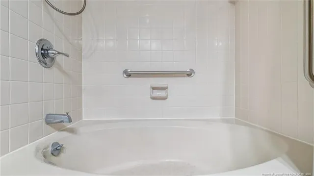 a bathroom with a white bath tub and a shower
