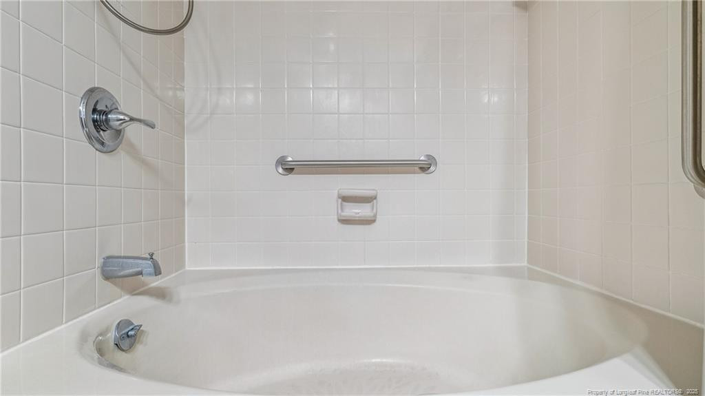 115 Beulah Hill Road South, Unit 111 Pinehurst, NC 28374 - Photo 13 of 32 a bathroom with a white bath tub and a shower