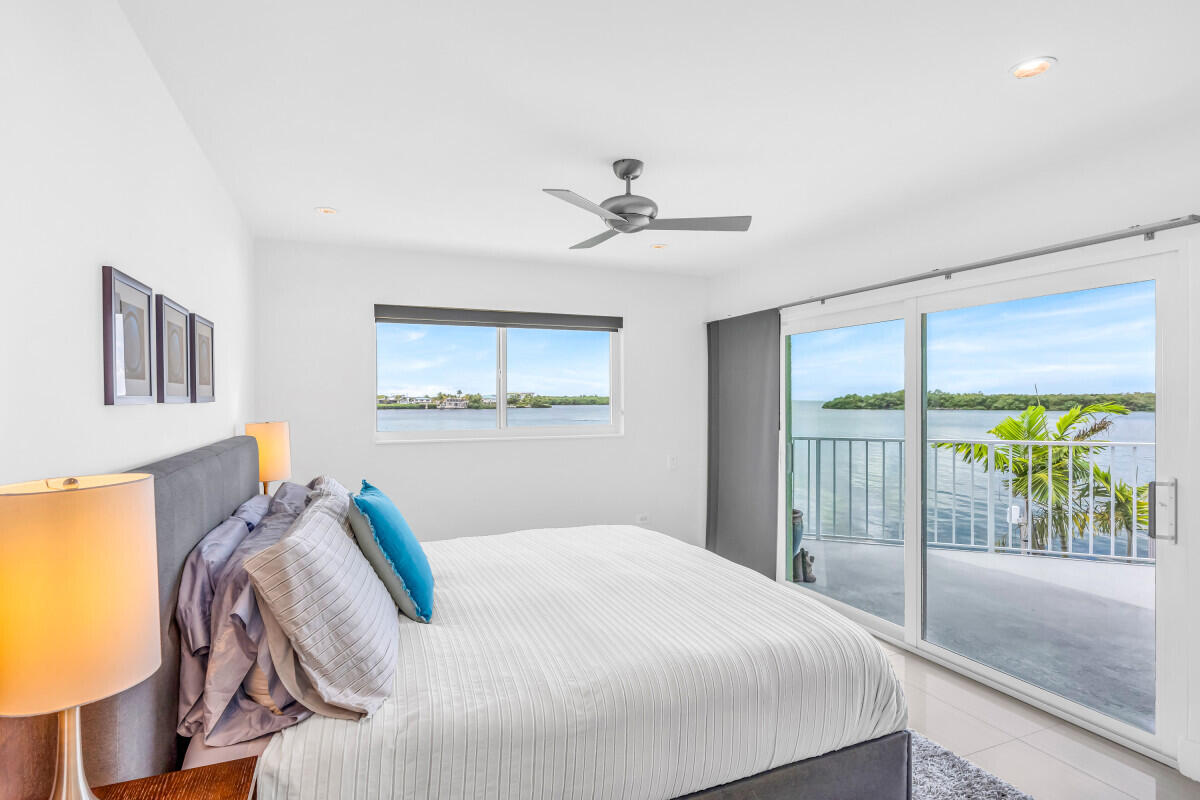 108 Sunset Drive Marathon, FL 33050 - Photo 14 of 46 a bedroom with a large bed and a chandelier