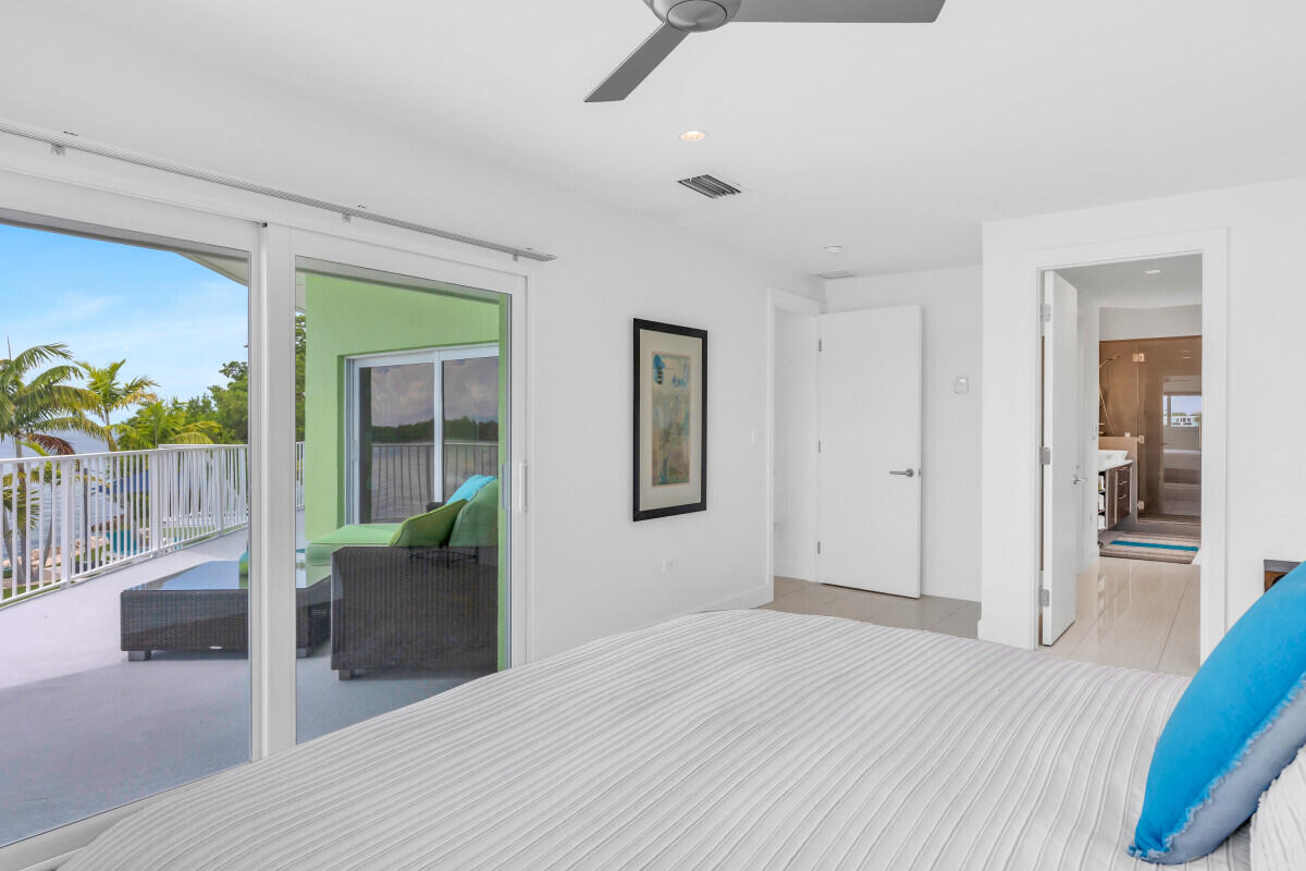 108 Sunset Drive Marathon, FL 33050 - Photo 15 of 46 a bedroom with a bed and glass door