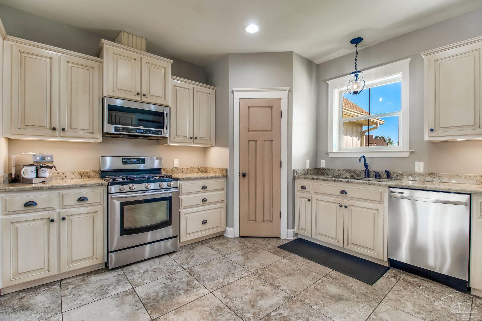 4940 Palmer Ridge Drive Milton, FL 32570 - Photo 18 of 53 a kitchen with granite countertop white cabinets stainless steel appliances and a sink