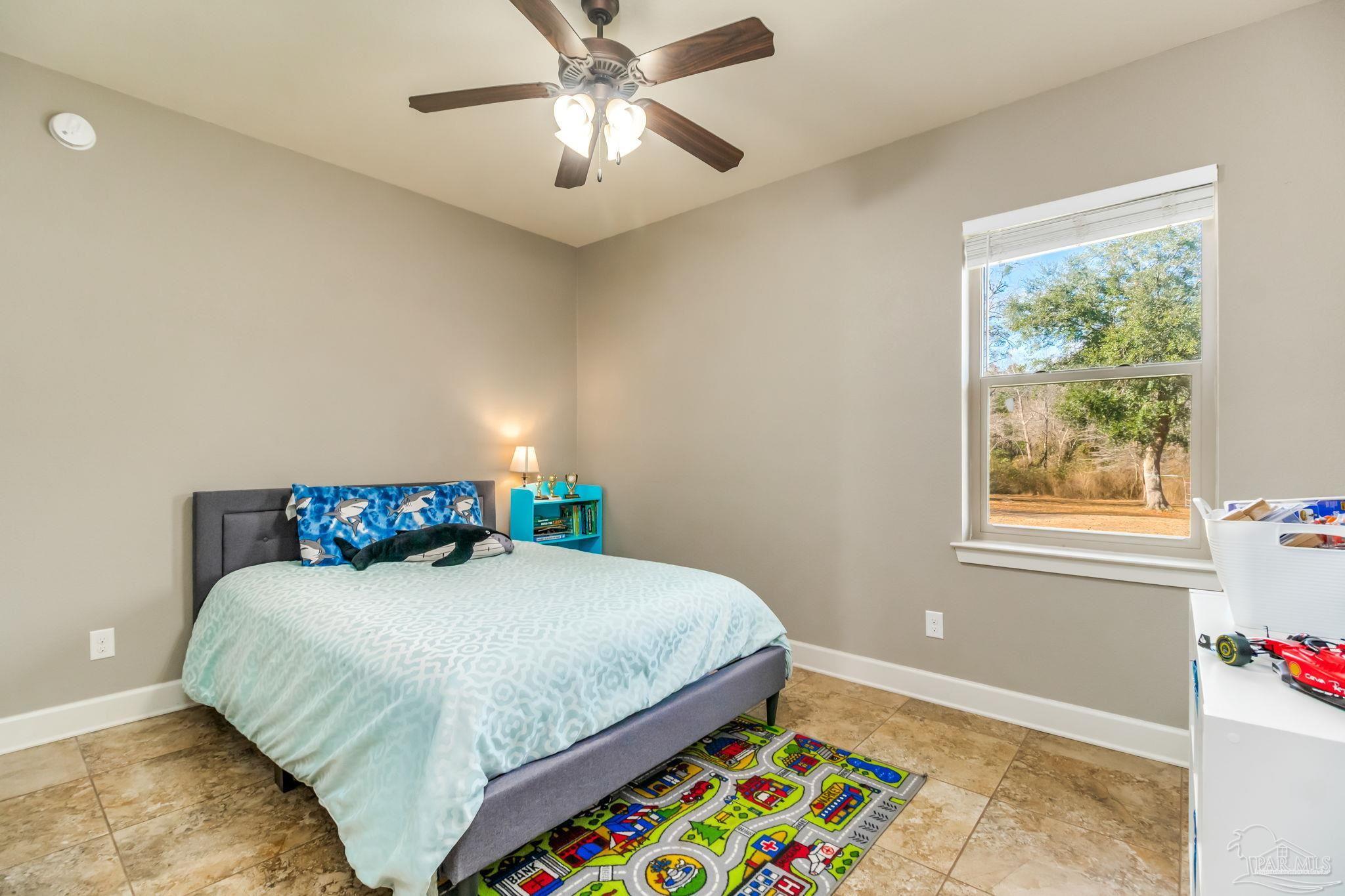 4940 Palmer Ridge Drive Milton, FL 32570 - Photo 33 of 53 a bedroom with a bed and a chandelier